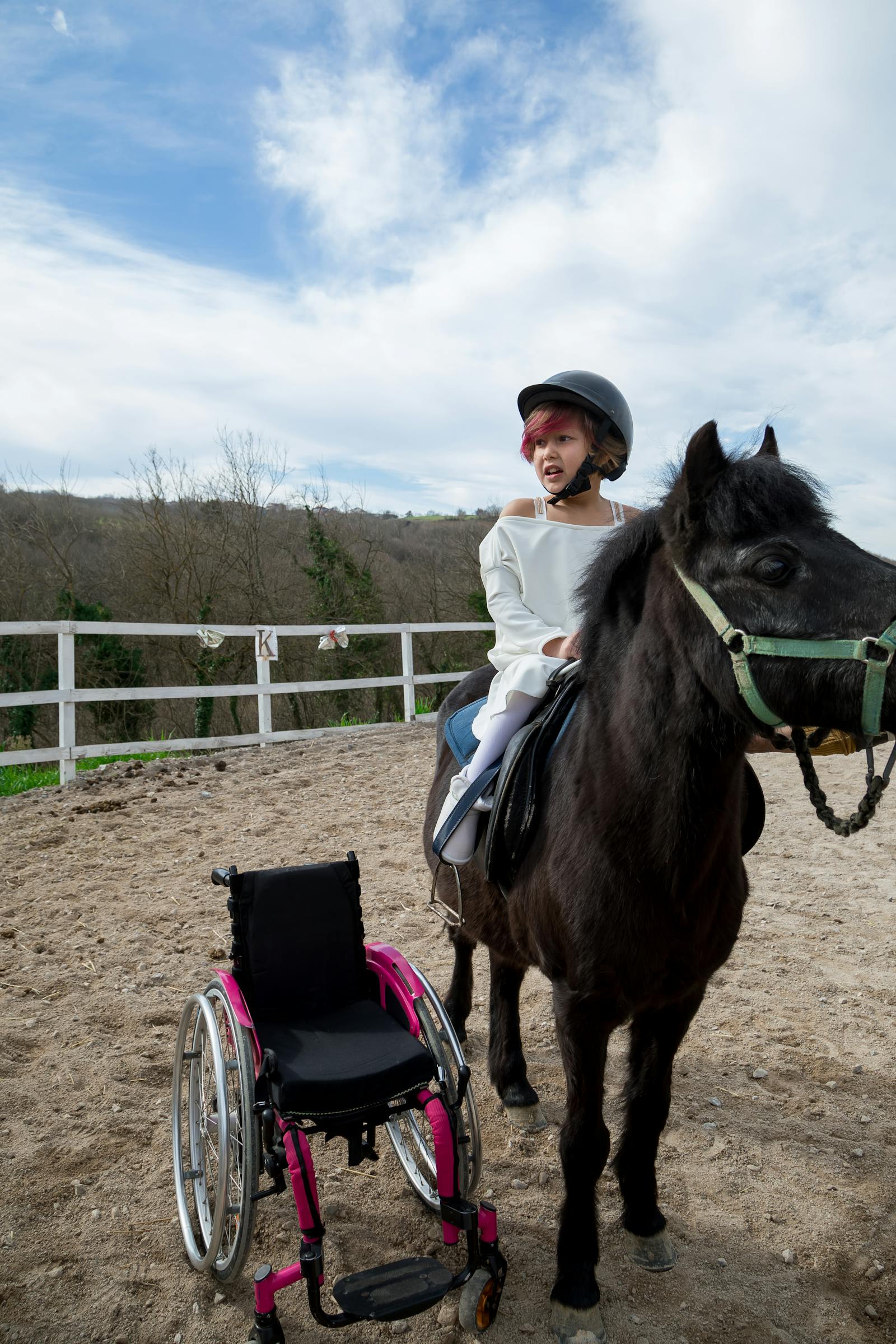 Enfant en casque sur un poney lors d'une séance d'équithérapie pour enfants à Martigues